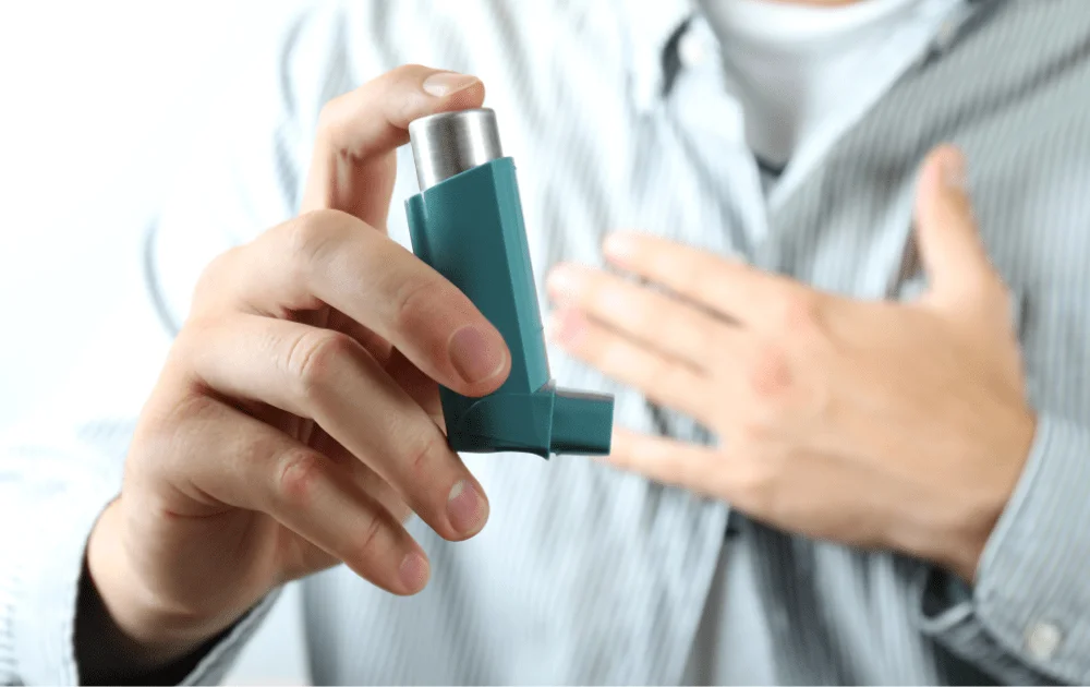 A asthma patient holds inhaler in hand